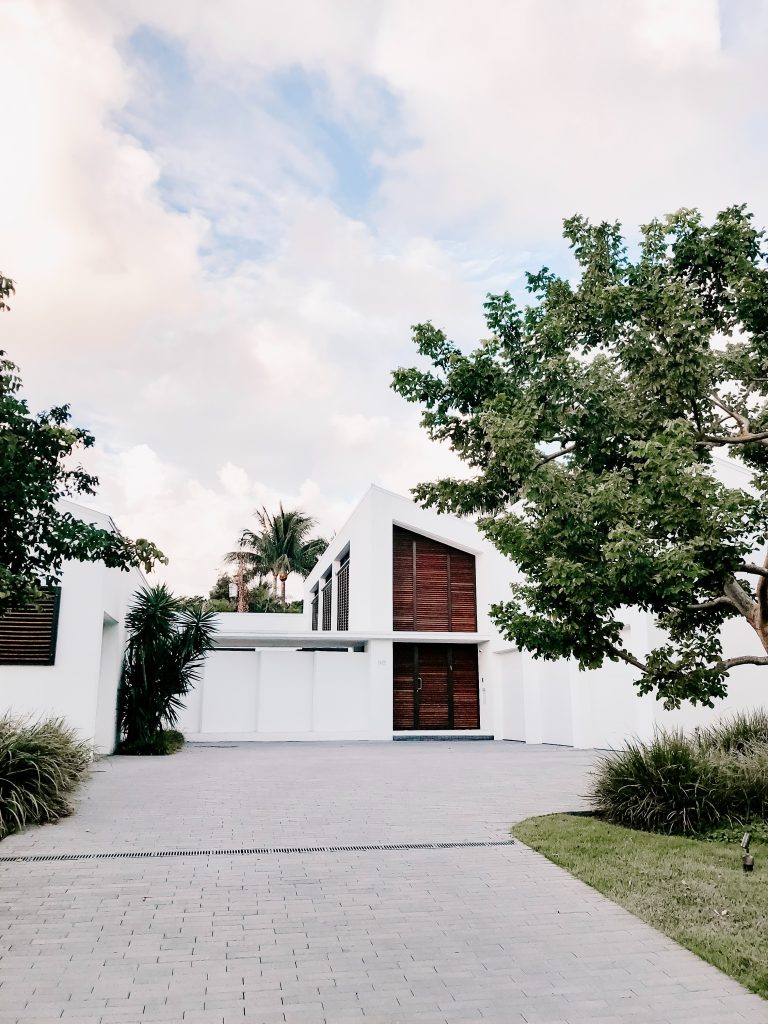 rendered white house with timber front door.